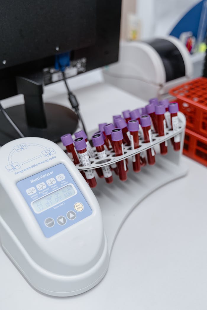 Close-up of blood samples with laboratory equipment and vacutainers on a table.